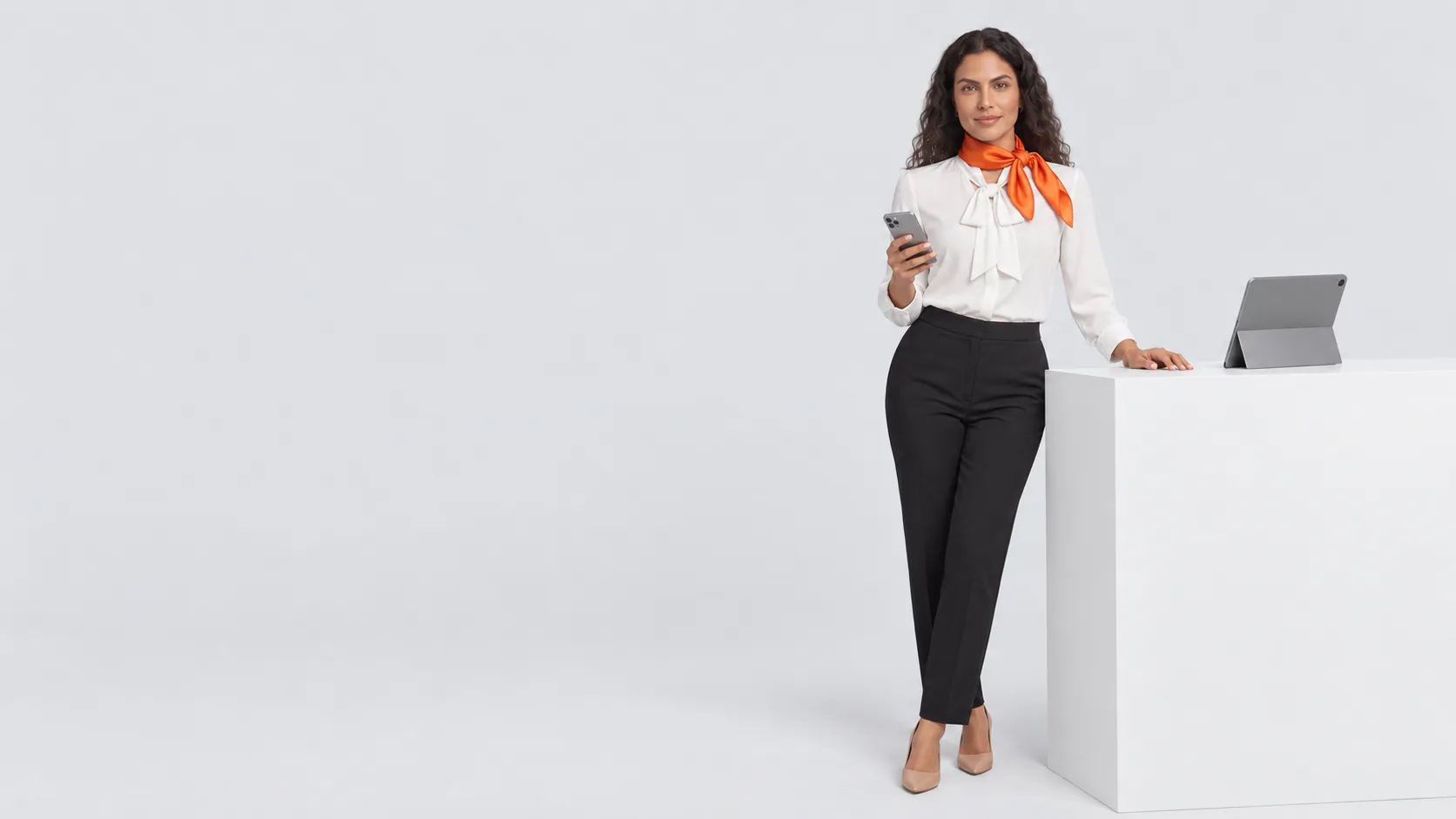 Coordenadora de clínica atrás de um balcão branco com o celular na mão e um tablet apoiado